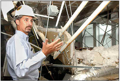   Shawn Dennis, Asst. Superintendant of Operations, views the damage at a local Pensacola School. (hurr-ivan_dam-pic03.jpg, 22 KB)  